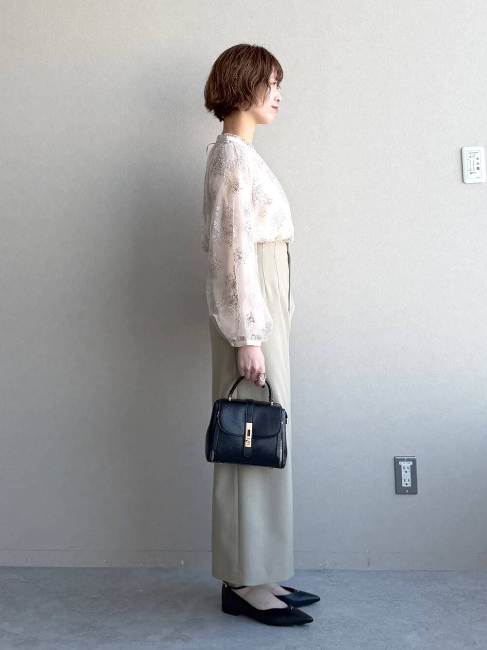 ブラック系のショルダーバッグ、ベージュ系のテーラードジャケット、ベージュ系のスカートを着用したレディースの冬コーディネートの5枚目の写真