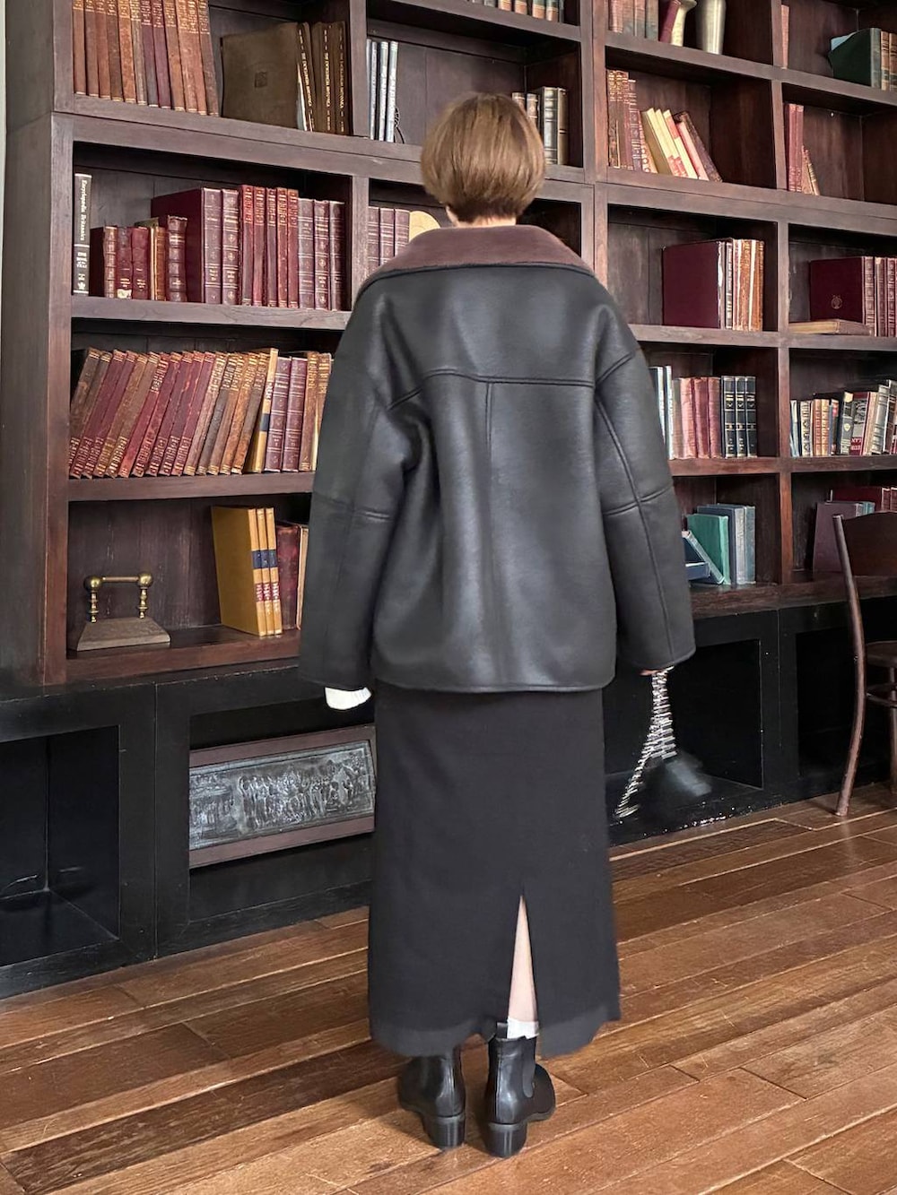 ホワイト系のニット/セーター、ブラック系のブルゾン、ブラック系のブーツを着用したレディースの秋コーディネートの3枚目の写真