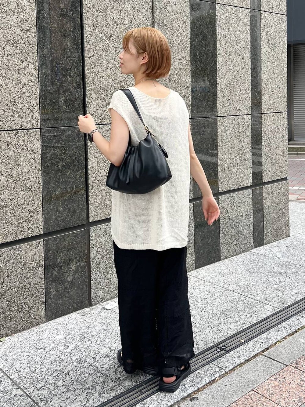 ホワイト系のニット/セーター、ブラック系のキャミソール、ブラック系のその他パンツを着用したレディースの夏コーディネートの4枚目の写真