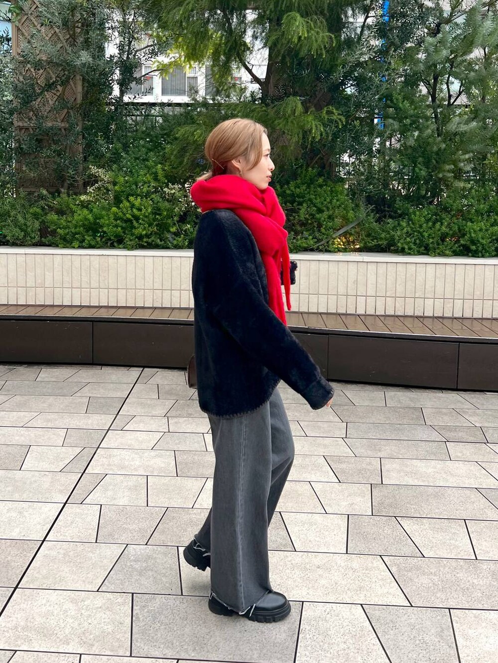 ブラック系のデニムパンツ、ブラック系のブーツ、ブラウン系のハンドバッグを着用したレディースの秋コーディネートの6枚目の写真