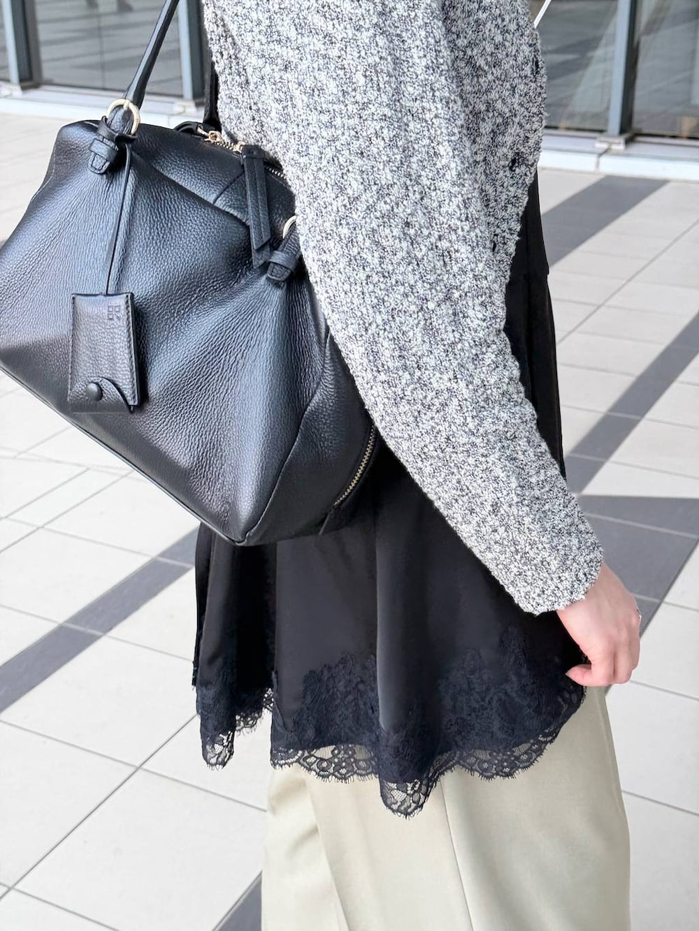 ブラック系のハンドバッグ、ブラック系のサンダル、ブラック系のキャミソールを着用したレディースの春コーディネートの5枚目の写真