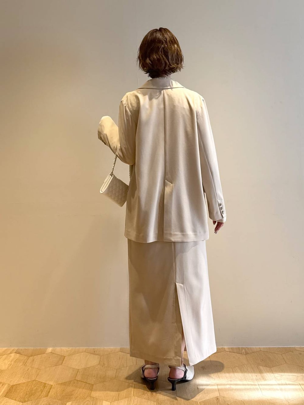 ホワイト系のサンダル、ベージュ系のテーラードジャケット、ベージュ系のスカートを着用したレディースの冬コーディネートの3枚目の写真