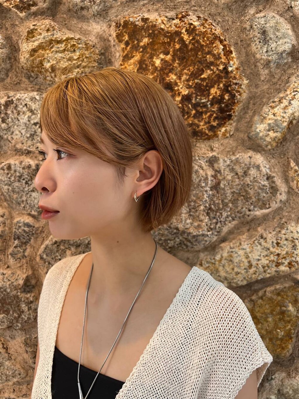 ホワイト系のニット/セーター、ブラック系のキャミソール、ブラック系のその他パンツを着用したレディースの夏コーディネートの2枚目の写真