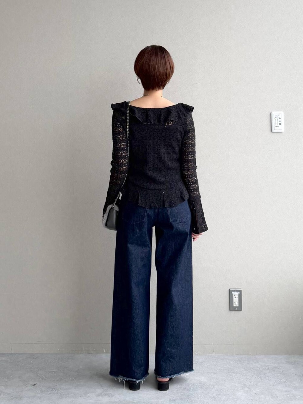 ブラック系のサンダル、ブルー系のデニムパンツ、ブラック系のシャツ/ブラウスを着用したレディースの秋コーディネートの3枚目の写真