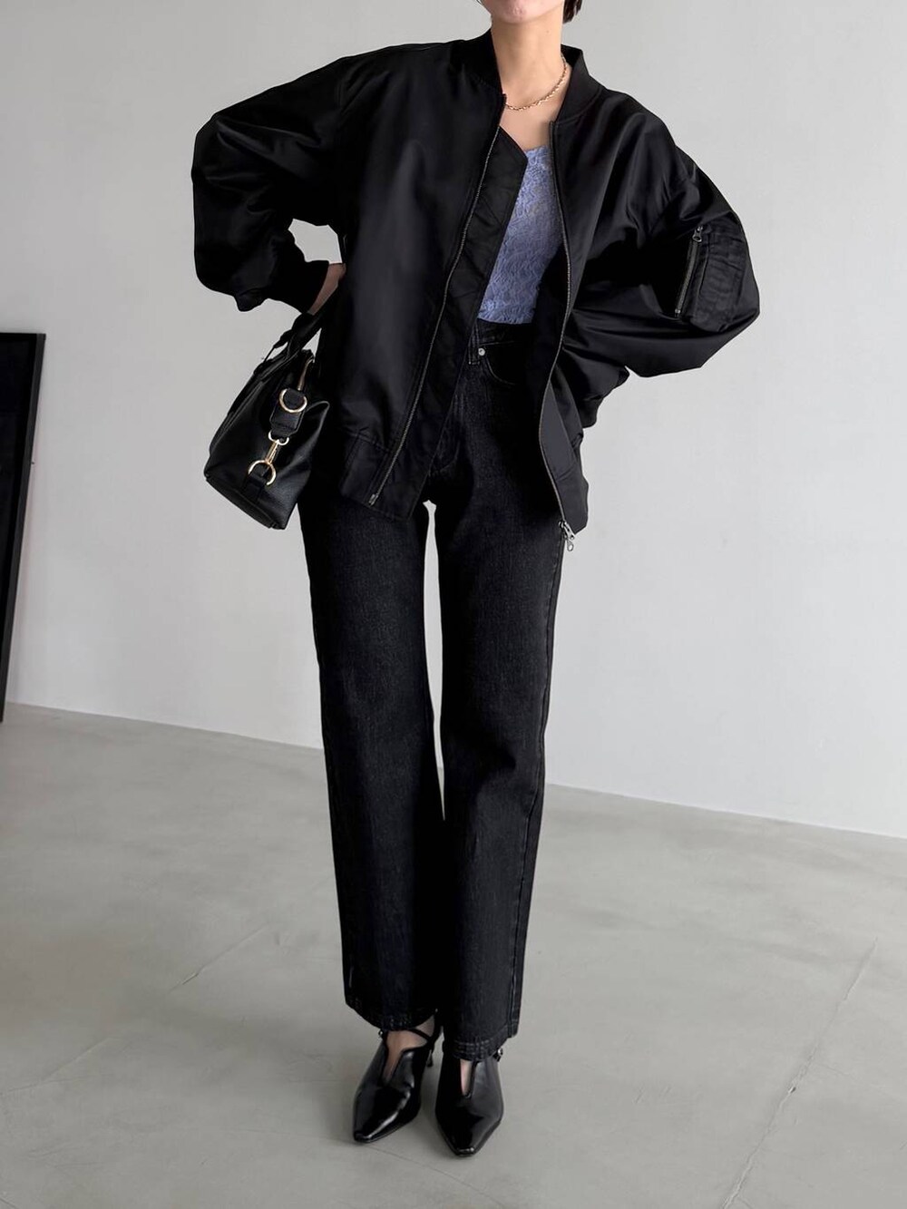 ブラック系のボストンバッグ、ブラック系のデニムパンツ、ブラック系のサンダルを着用したレディースの冬コーディネートの5枚目の写真