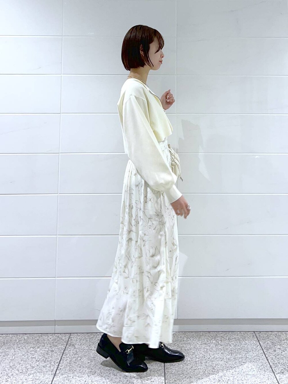 ブラック系のローファー、ホワイト系のタンクトップ、ホワイト系のハンドバッグを着用したレディースの冬コーディネートの2枚目の写真