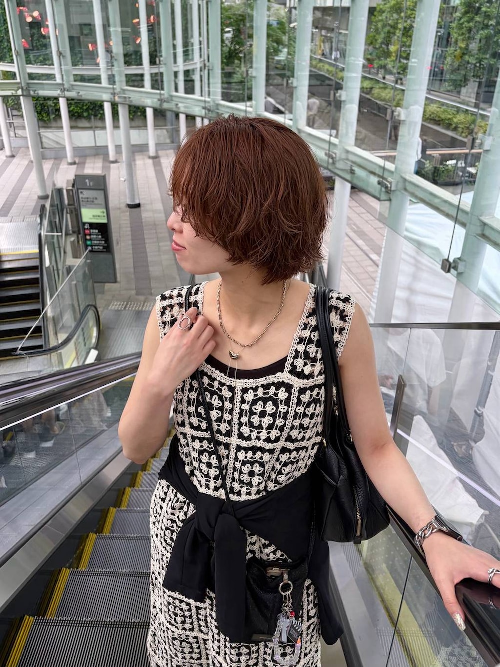 その他のワンピース、ブラック系のハンドバッグ、ブルー系のデニムパンツを着用したレディースの夏コーディネートの4枚目の写真