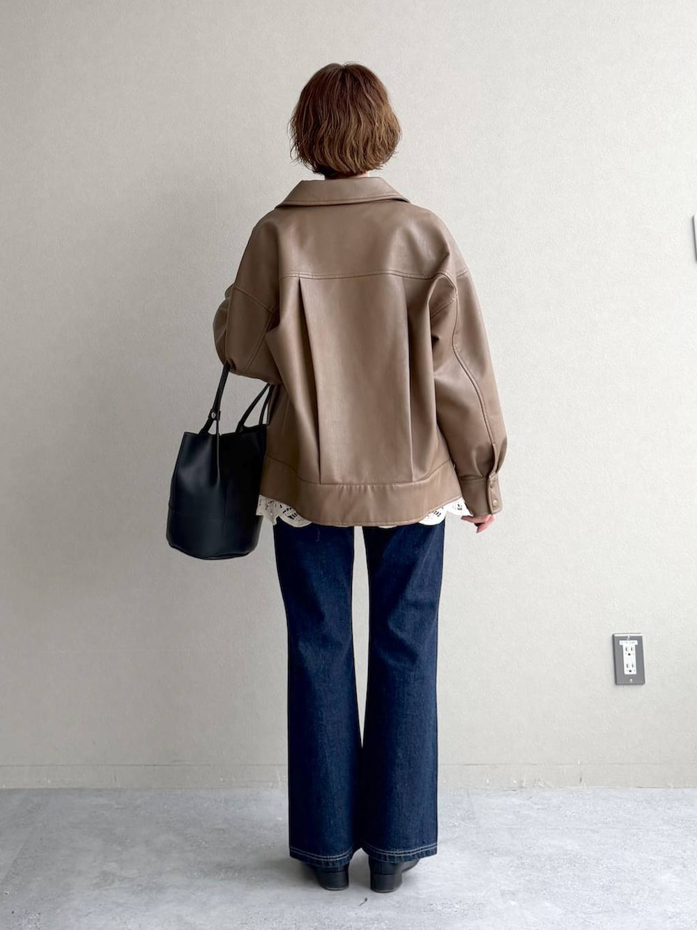 ブラック系のローファー、ブルー系のデニムパンツ、ブラウン系のブルゾンを着用したレディースの春コーディネートの3枚目の写真