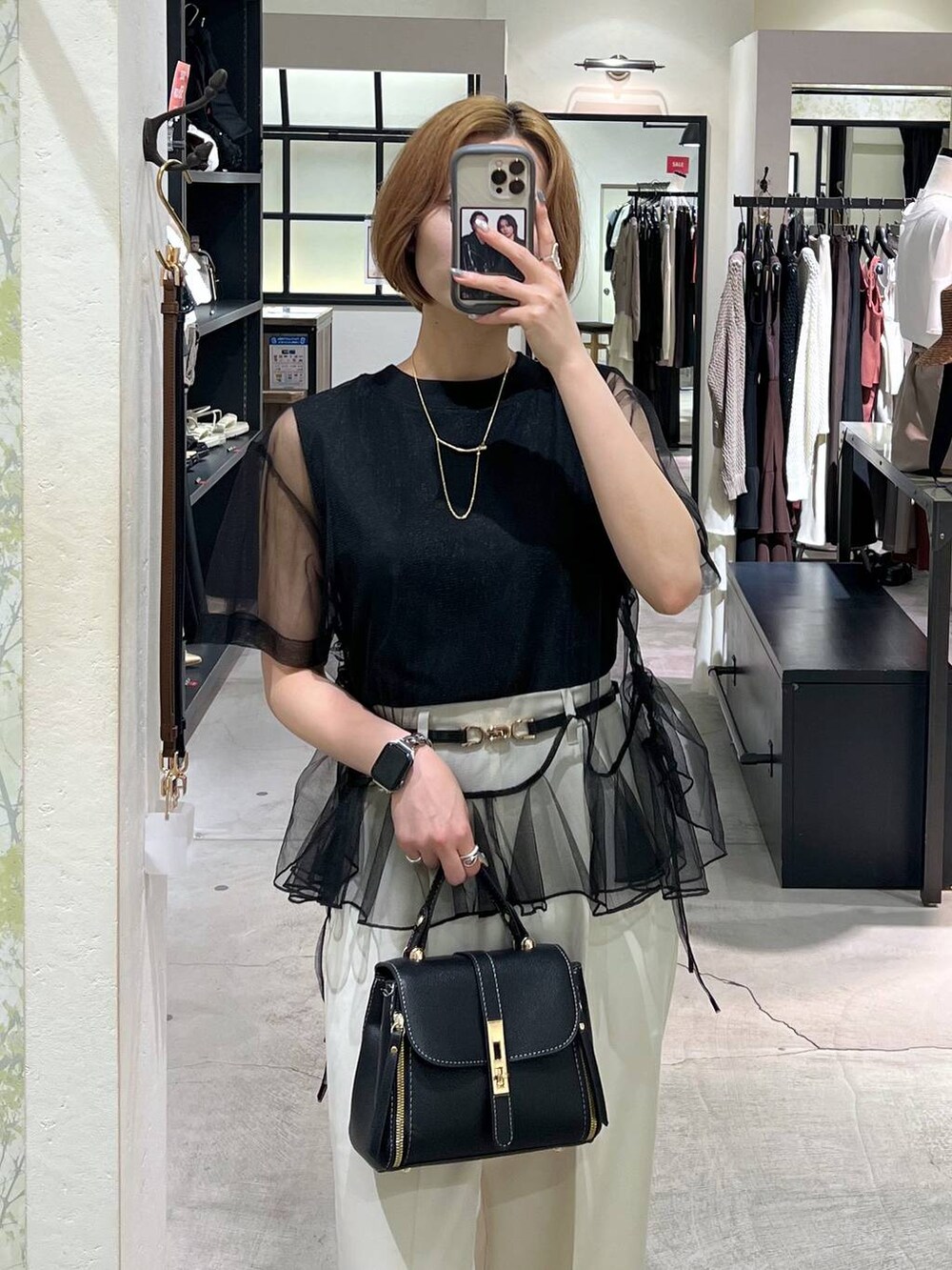 ブラック系のパンプス、ブラック系のショルダーバッグ、ブラック系のTシャツ/カットソーを着用したレディースの夏コーディネートの5枚目の写真