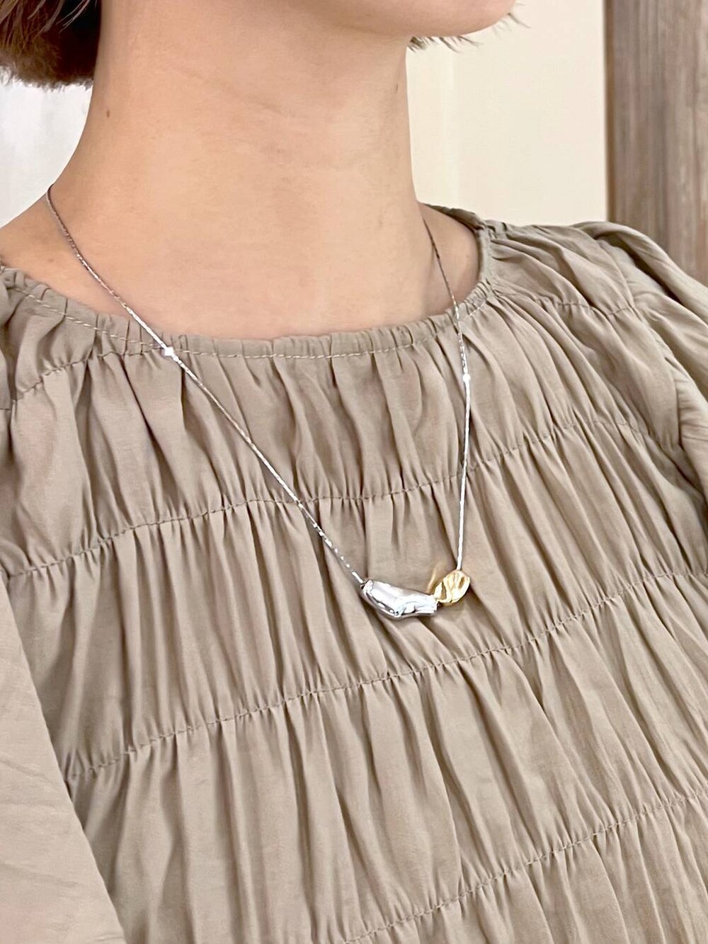 ブラック系のサンダル、ブラック系のショルダーバッグ、ベージュ系のワンピースを着用したレディースの春コーディネートの6枚目の写真