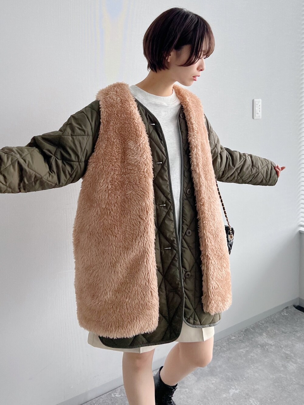 グリーン系のブルゾン、ブラック系のブーツ、ホワイト系のその他パンツを着用したレディースの夏コーディネートの4枚目の写真