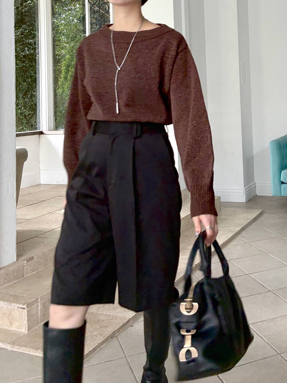 ブラウン系のニット/セーター、ブラック系のボストンバッグ、ブラック系のブーツを着用したレディースの冬コーディネートの8枚目の写真