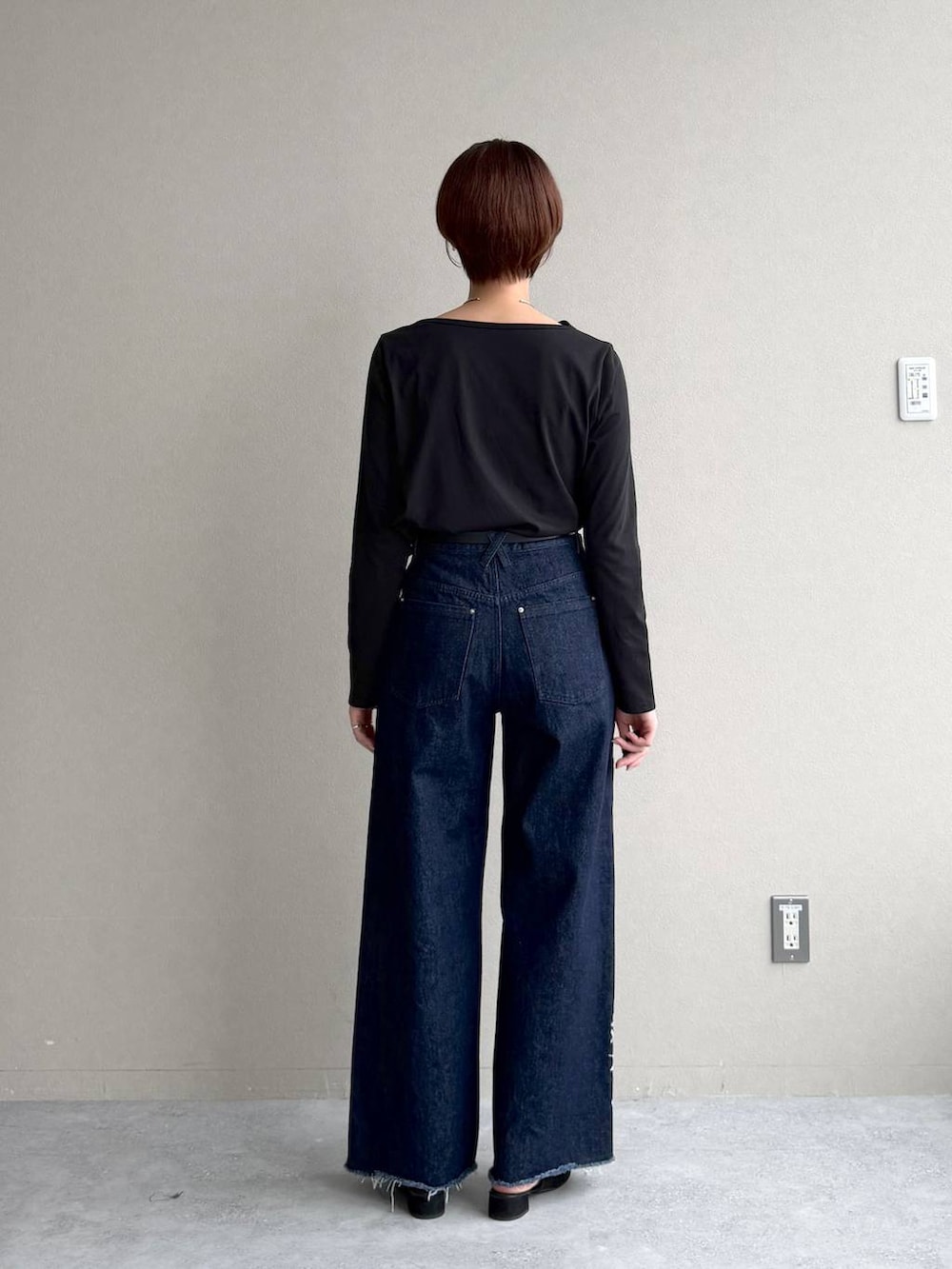 ブラック系のサンダル、ブルー系のデニムパンツ、ブラック系のTシャツ/カットソーを着用したレディースの秋コーディネートの7枚目の写真