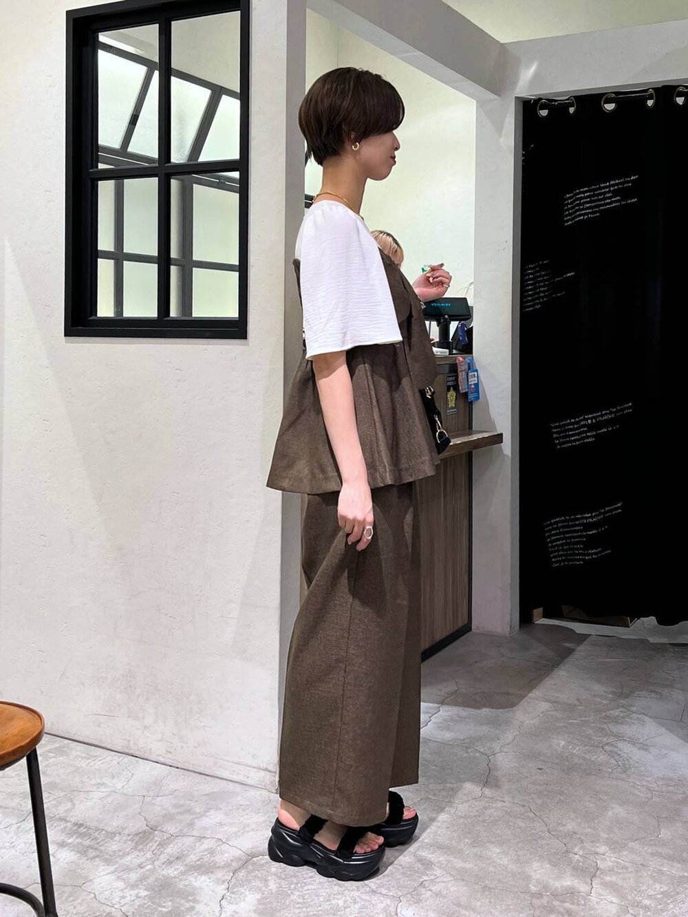 ブラック系のサンダル、ブラック系のボストンバッグ、ブラウン系のその他パンツを着用したレディースの夏コーディネートの2枚目の写真