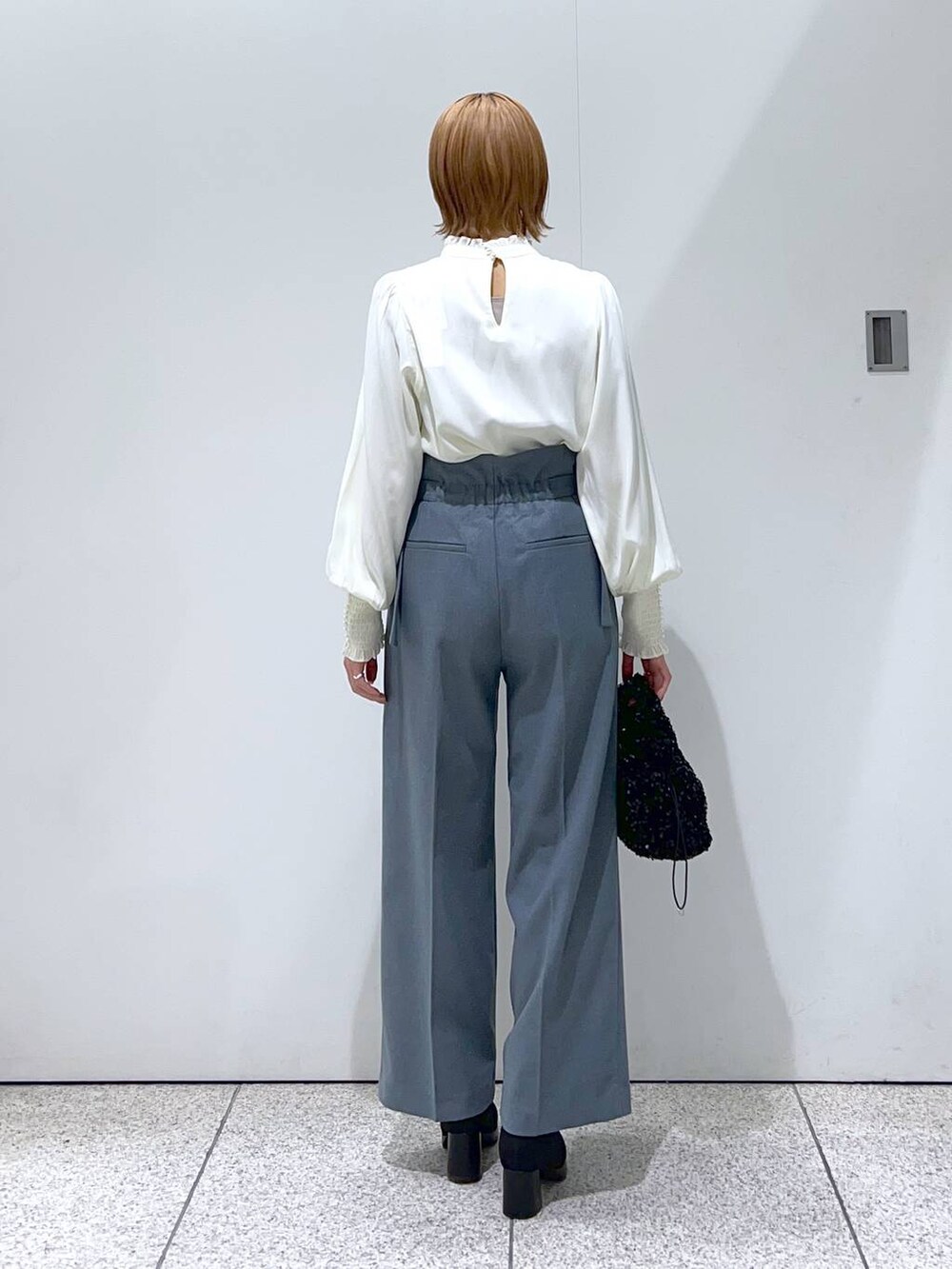 ブルー系のその他パンツ、ブラック系のブーツ、ブラック系のハンドバッグを着用したレディースの冬コーディネートの3枚目の写真