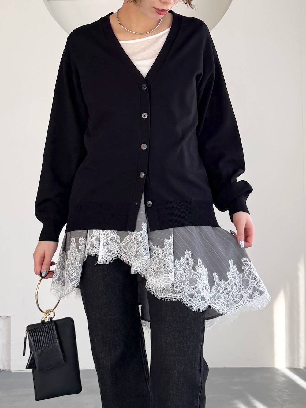 ブラック系のデニムパンツ、ブラック系のパンプス、ブラック系のショルダーバッグを着用したレディースの冬コーディネートの4枚目の写真