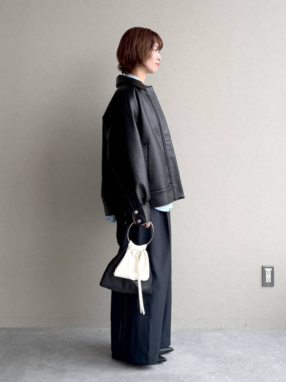 ブルー系のシャツ/ブラウス、ブラック系のパンプス、ブラック系のブルゾンを着用したレディースの冬コーディネートの2枚目の写真