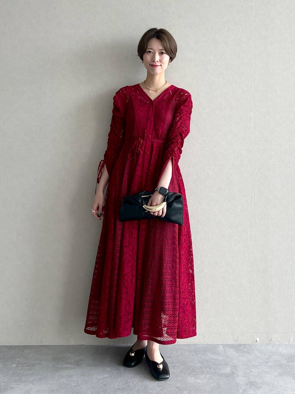 ブラック系のブルゾン、ブラック系のハンドバッグ、レッド系のワンピースを着用したレディースの秋コーディネートの5枚目の写真