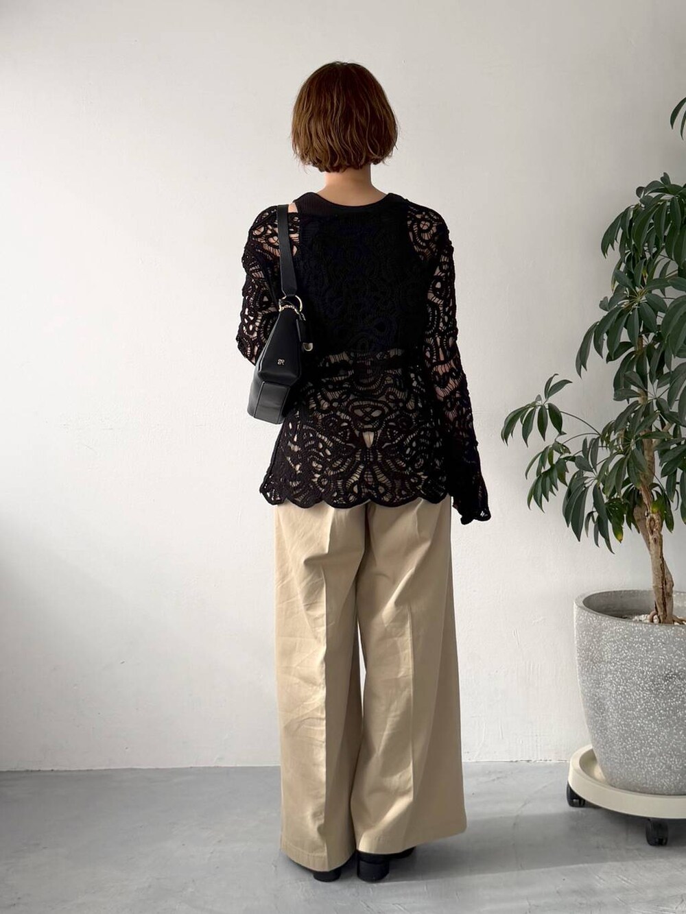 ブラック系のカーディガン/ボレロ、ブラック系のショルダーバッグ、ベージュ系のチノパンツを着用したレディースの春コーディネートの3枚目の写真