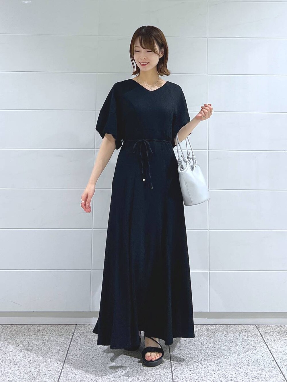 ブラック系のサンダル、シルバー系のハンドバッグ、グリーン系のミリタリージャケットを着用したレディースの夏コーディネートの5枚目の写真