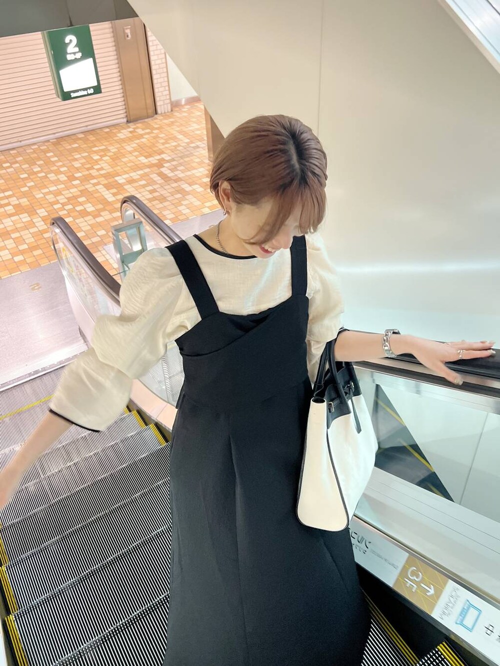 ブラック系のトートバッグ、ホワイト系のシャツ/ブラウス、ブラック系のパンプスを着用したレディースの春コーディネートの8枚目の写真