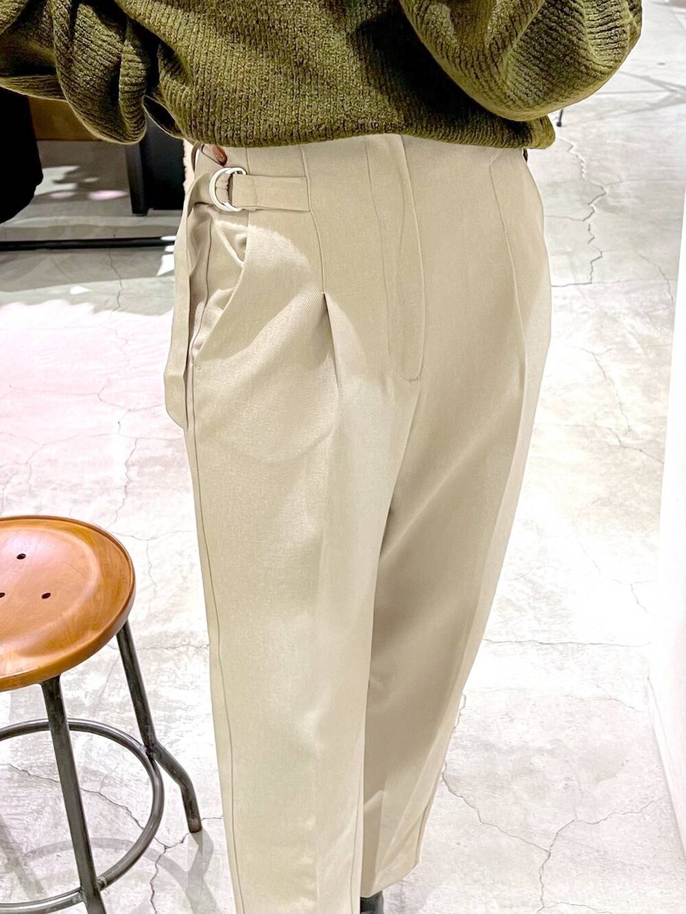 ブラック系のショルダーバッグ、ブラック系のブーツ、グリーン系のニット/セーターを着用したレディースの秋コーディネートの6枚目の写真