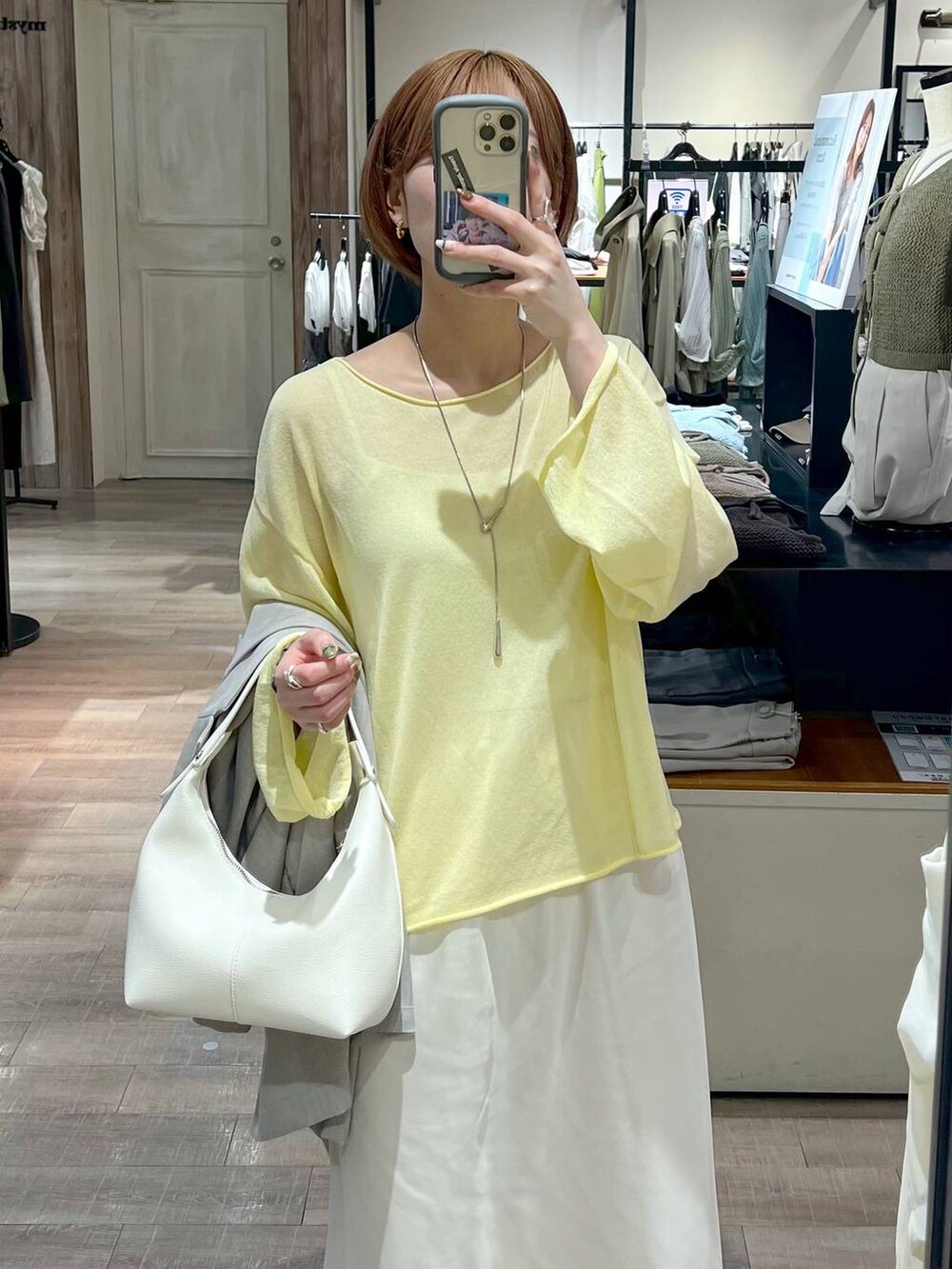 イエロー系のニット/セーター、グレー系のテーラードジャケット、ホワイト系のスカートを着用したレディースの春コーディネートの7枚目の写真