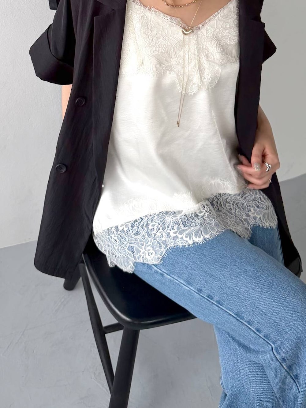 ブルー系のデニムパンツ、ホワイト系のキャミソール、ブラック系のサンダルを着用したレディースの春コーディネートの2枚目の写真