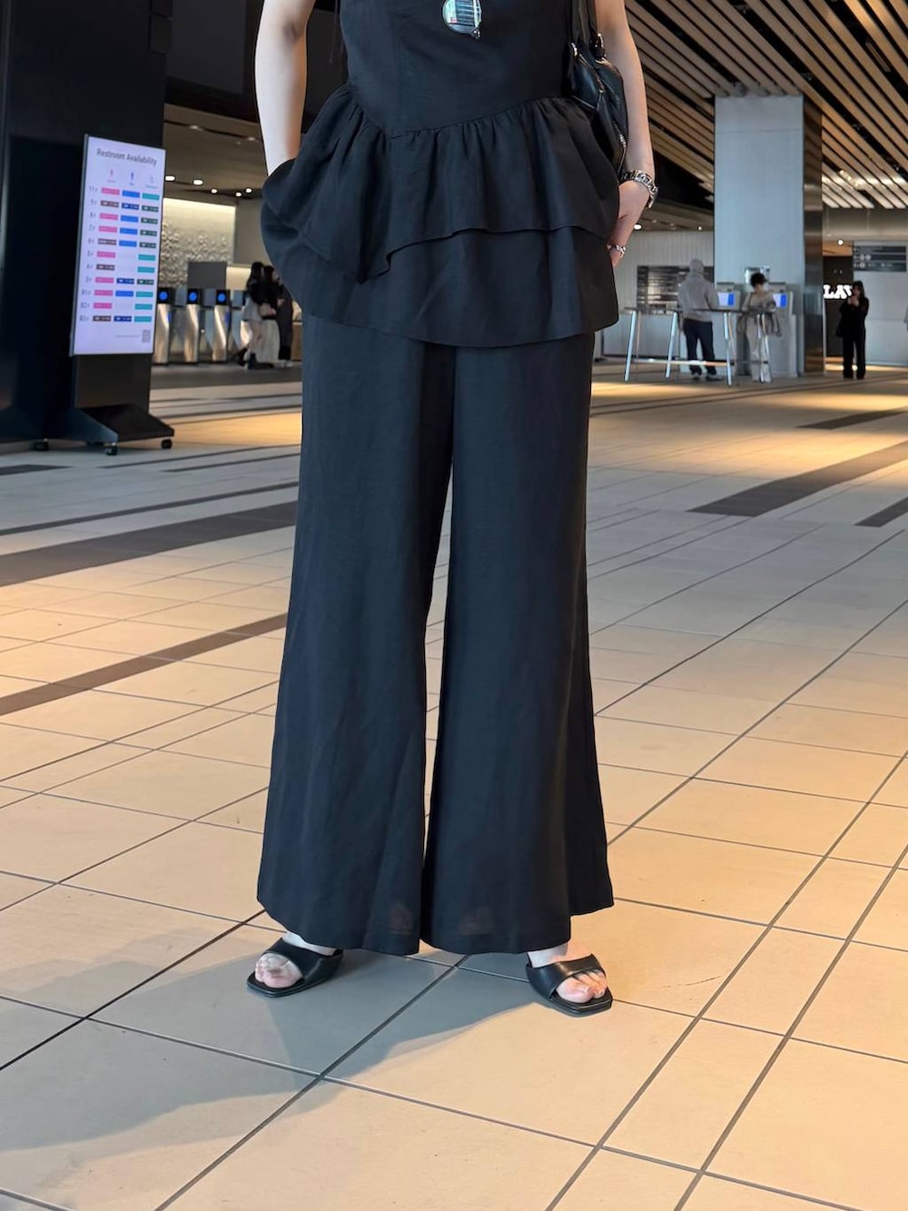 ブラック系のハンドバッグ、ブラック系のサンダル、ブラック系のシャツ/ブラウスを着用したレディースの春コーディネートの5枚目の写真