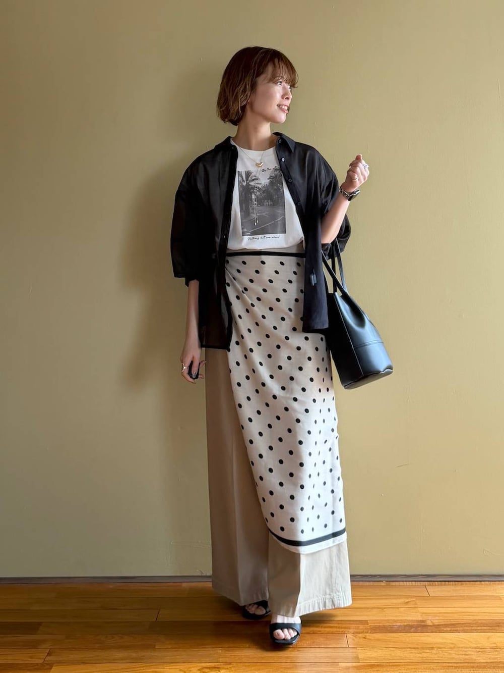 ブラック系のサンダル、ブラック系のシャツ/ブラウス、ベージュ系のチノパンツを着用したレディースの春コーディネートの5枚目の写真