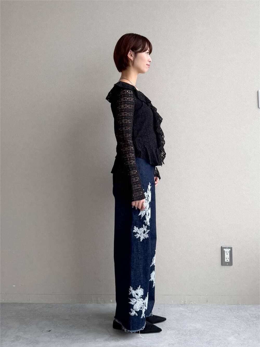 ブラック系のサンダル、ブルー系のデニムパンツ、ブラック系のシャツ/ブラウスを着用したレディースの秋コーディネートの2枚目の写真