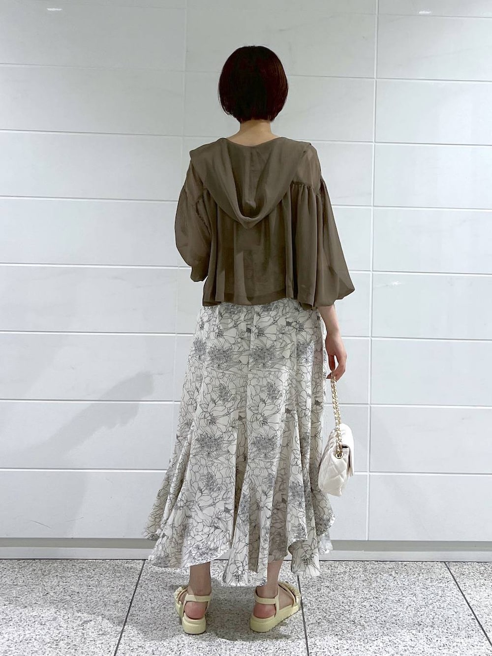 ホワイト系のサンダル、ホワイト系のショルダーバッグ、ブラウン系のパーカーを着用したレディースの夏コーディネートの3枚目の写真