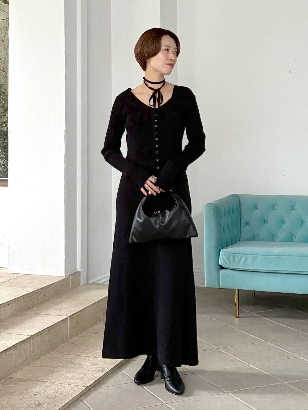 ブラック系のハンドバッグ、ホワイト系のステンカラーコート、ブラック系のブーツを着用したレディースの秋コーディネートの5枚目の写真