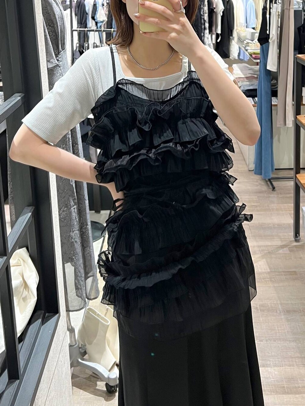 ブラック系のスカート、ブラック系のキャミソール、ブラック系のショルダーバッグを着用したレディースの夏コーディネートの4枚目の写真