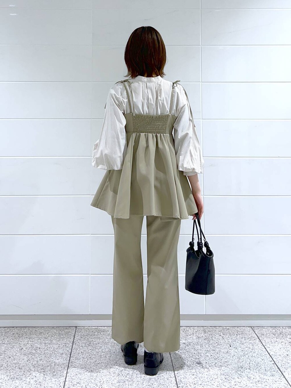 ブラック系のローファー、ブラック系のハンドバッグ、ベージュ系のシャツ/ブラウスを着用したレディースの春コーディネートの3枚目の写真