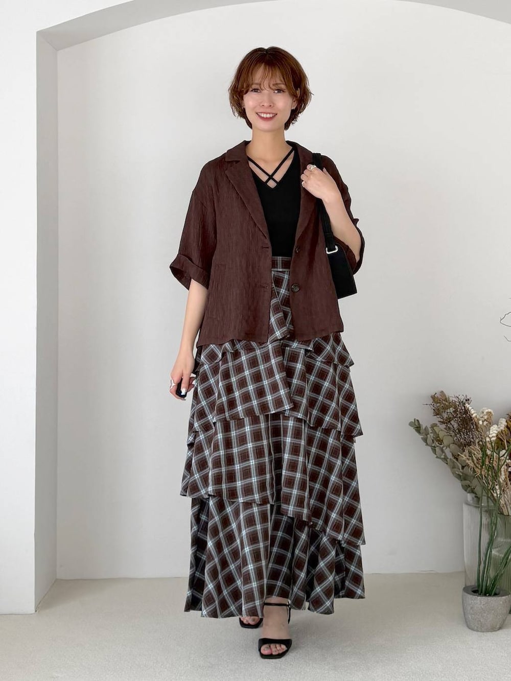ブラウン系のテーラードジャケット、ブルー系のスカート、ブラック系のTシャツ/カットソーを着用したレディースの夏コーディネートの5枚目の写真