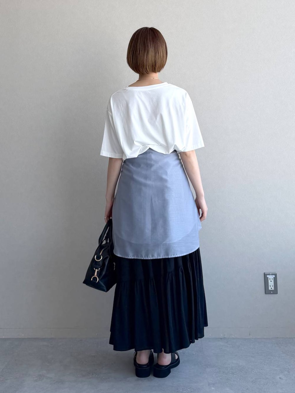 ブラック系のボストンバッグ、ブルー系のシャツ/ブラウス、ブラック系のサンダルを着用したレディースの春コーディネートの3枚目の写真