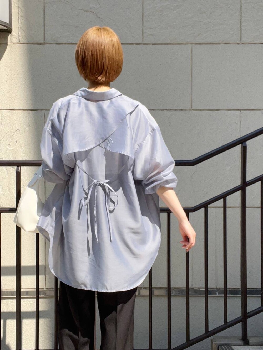 ブラック系のサンダル、ホワイト系のショルダーバッグ、ブラック系のスラックスを着用したレディースの夏コーディネートの5枚目の写真