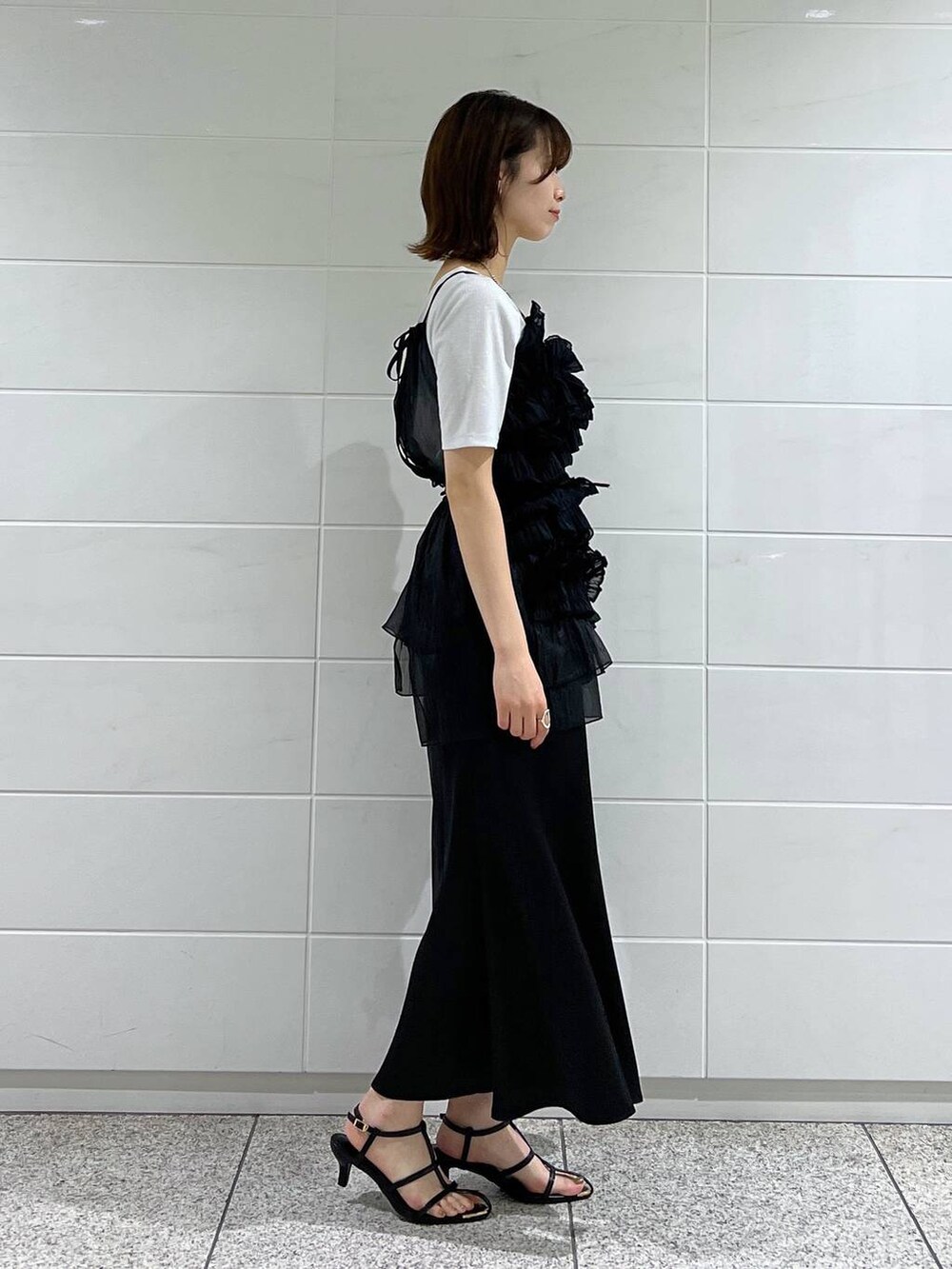 ブラック系のスカート、ブラック系のキャミソール、ブラック系のショルダーバッグを着用したレディースの夏コーディネートの2枚目の写真