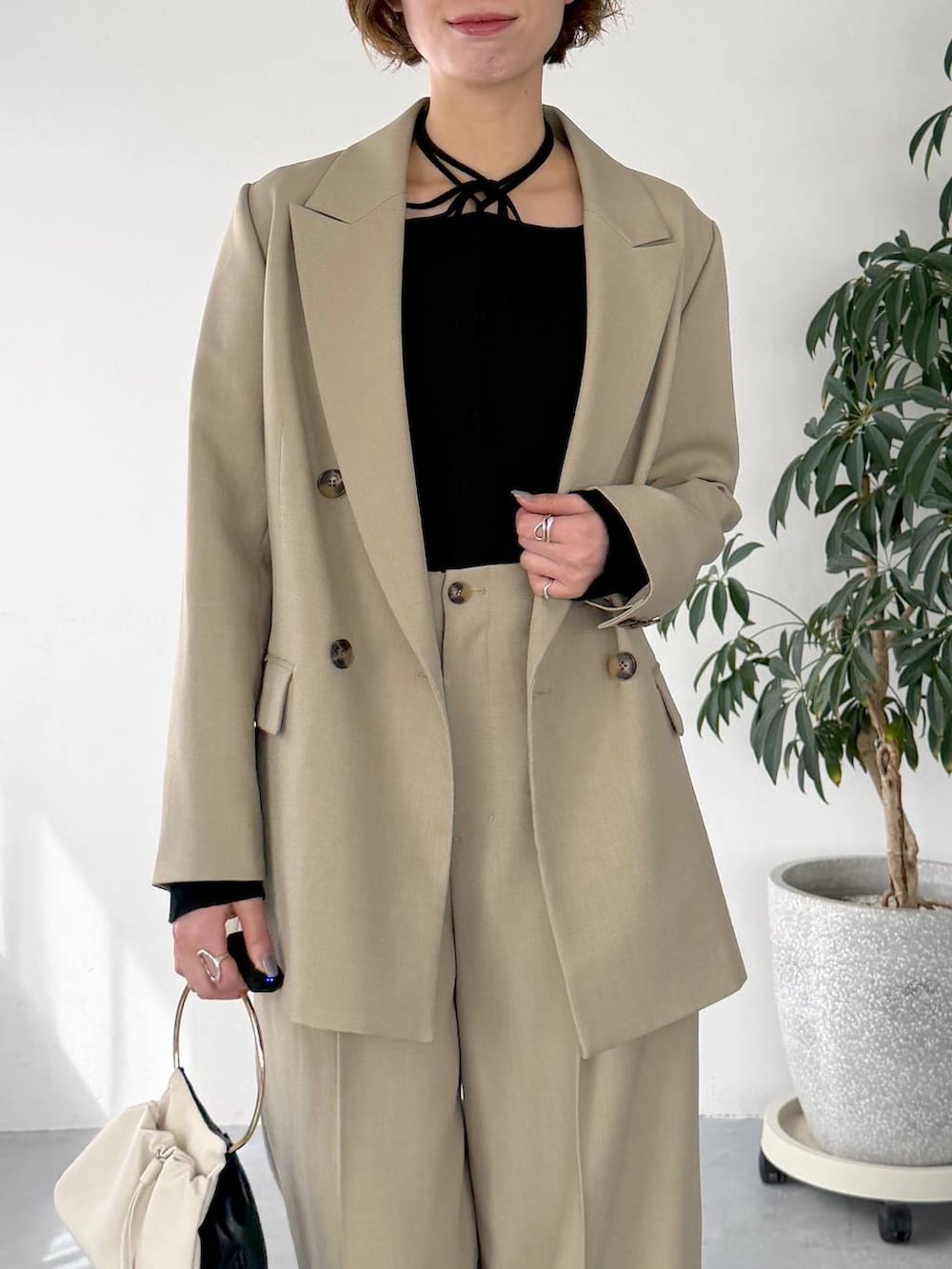 ベージュ系のテーラードジャケット、ベージュ系のその他パンツ、ブラック系のサンダルを着用したレディースの春コーディネートの4枚目の写真