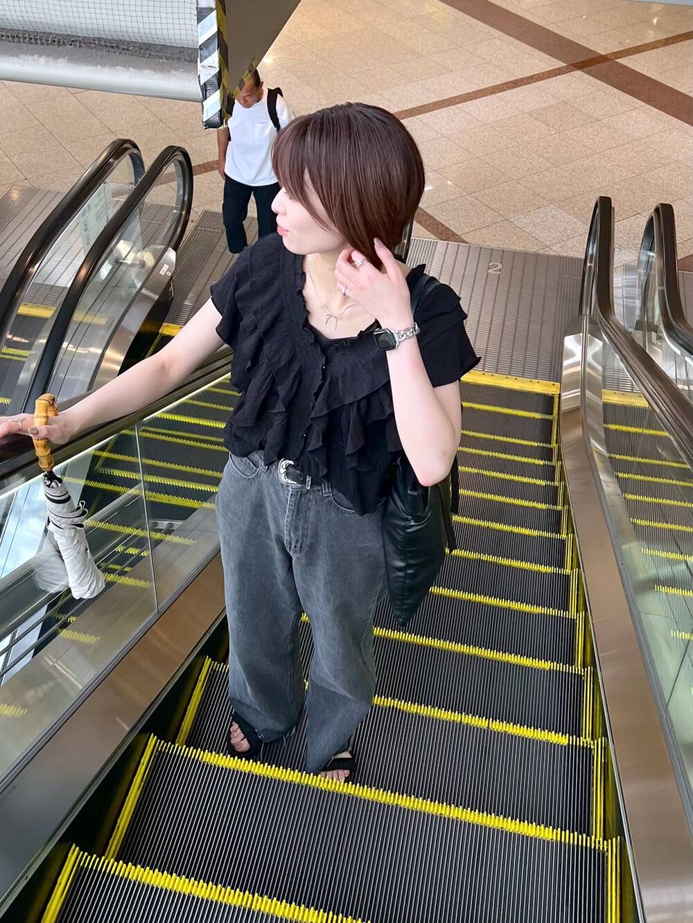 ブラック系のサンダル、ブラック系のシャツ/ブラウス、ブラック系のデニムパンツを着用したレディースの夏コーディネートの4枚目の写真