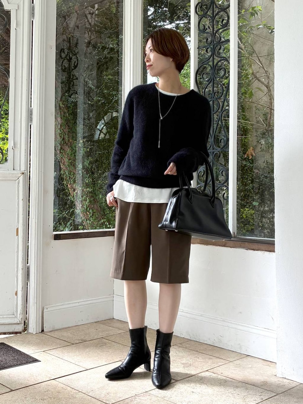 ホワイト系のTシャツ/カットソー、ブラック系のブーツ、ブラック系のトートバッグを着用したレディースの秋コーディネートの4枚目の写真