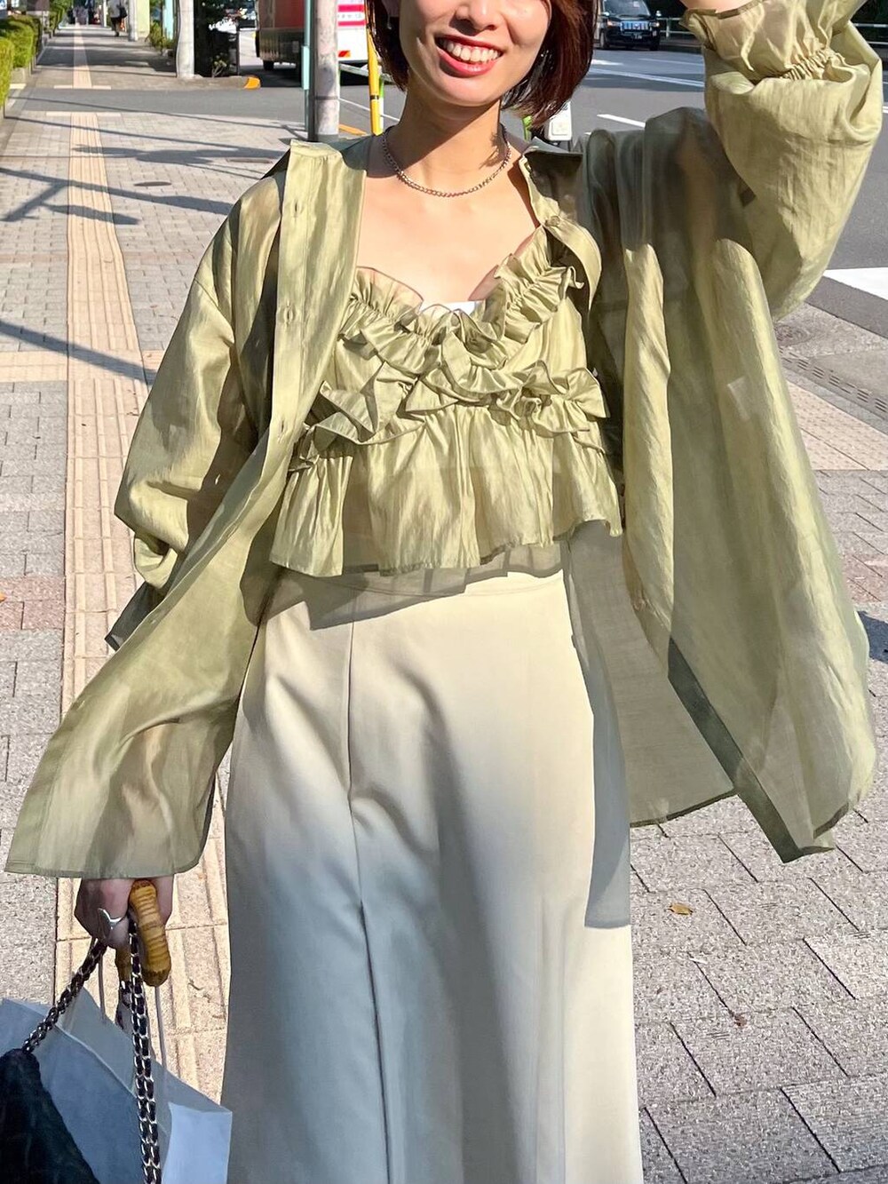 ブラック系のサンダル、ブラック系のショルダーバッグ、ホワイト系のスカートを着用したレディースの夏コーディネートの4枚目の写真