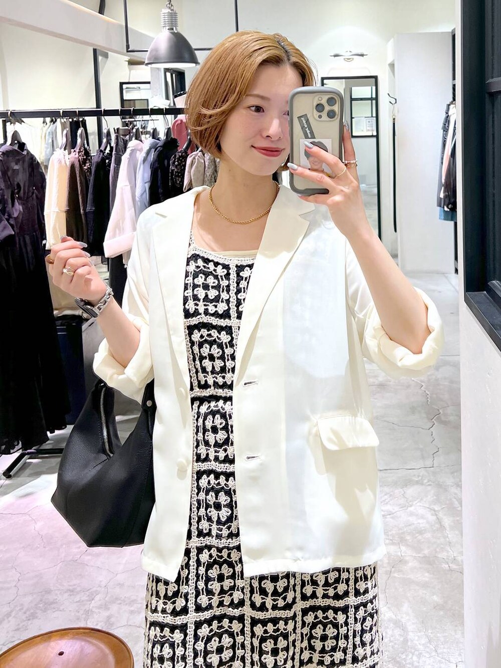 ブルー系のデニムパンツ、ベージュ系のサンダル、ブラック系のショルダーバッグを着用したレディースの夏コーディネートの5枚目の写真