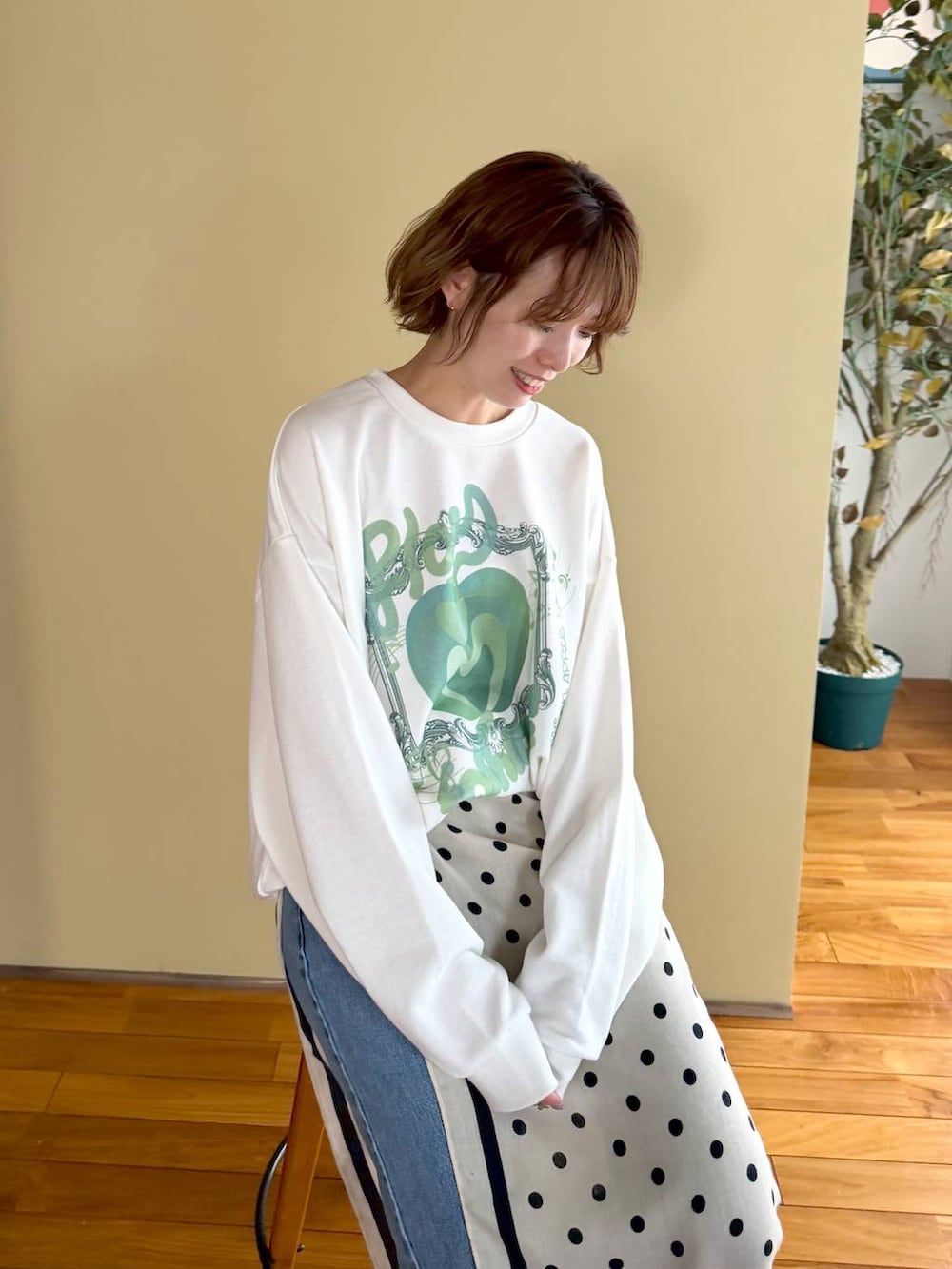 ブラック系のボストンバッグ、ブルー系のデニムパンツ、ブラック系のパンプスを着用したレディースの春コーディネートの2枚目の写真