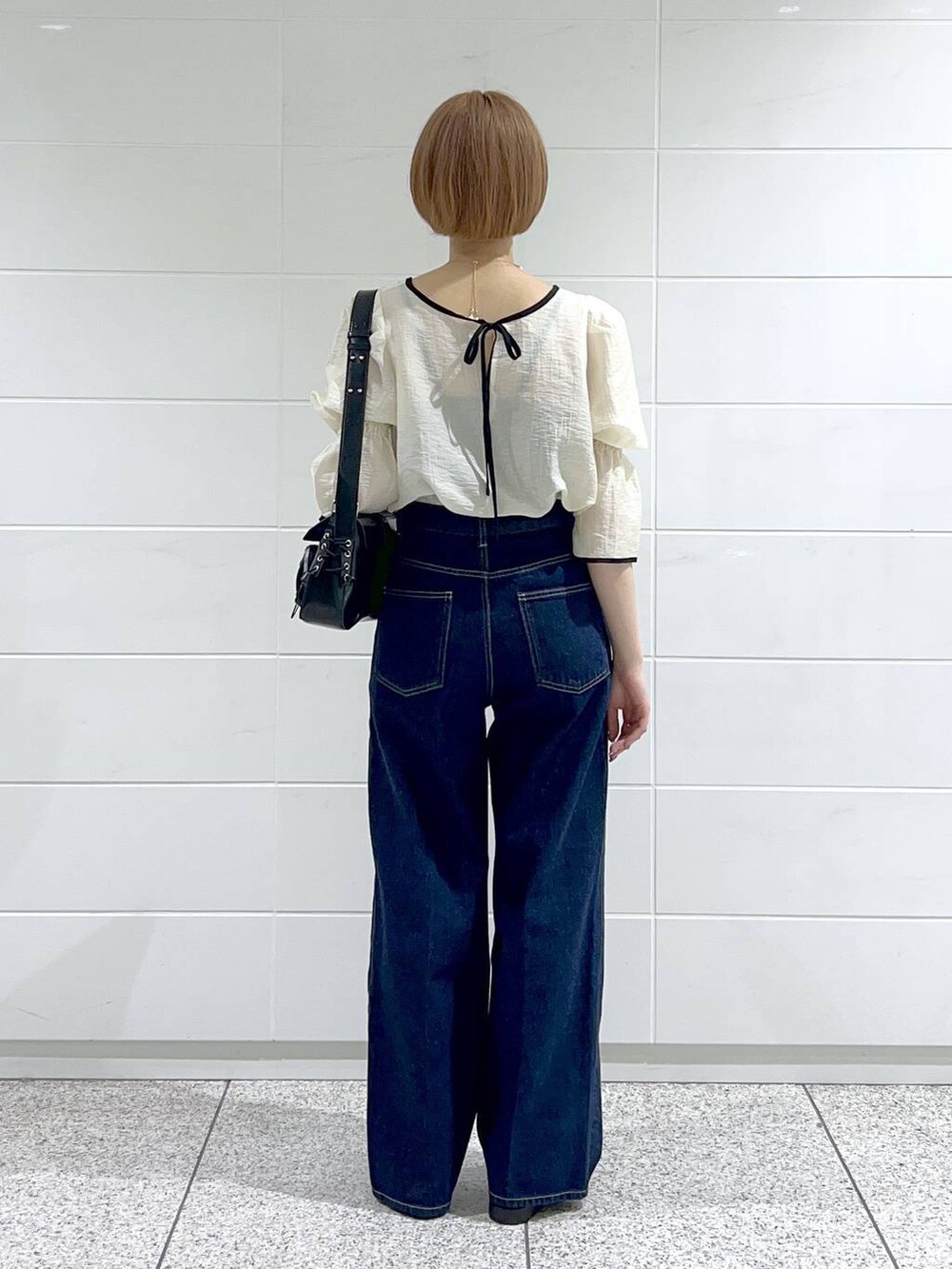 ブラック系のサンダル、ブルー系のデニムパンツ、ホワイト系のシャツ/ブラウスを着用したレディースの春コーディネートの3枚目の写真