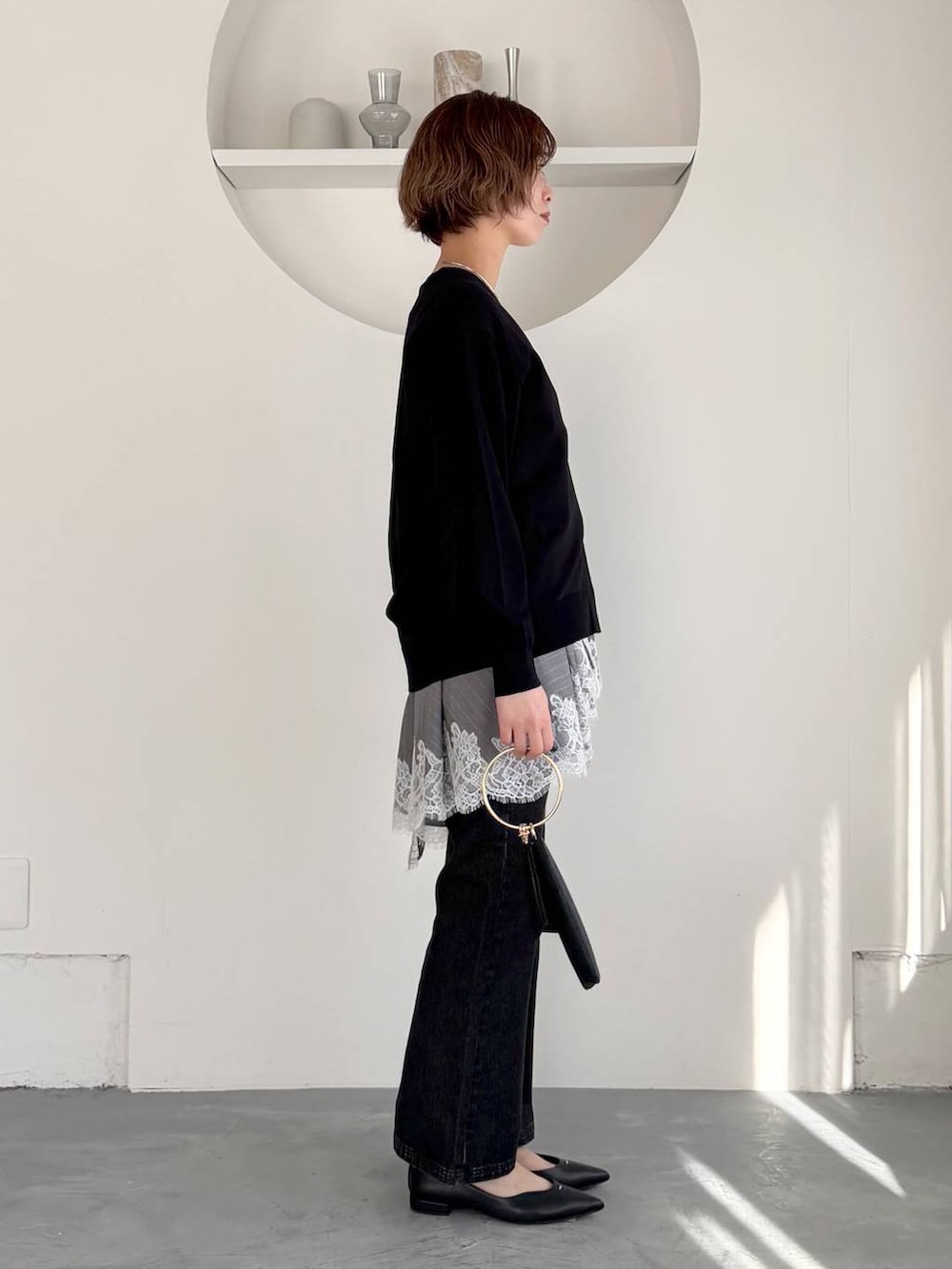 ブラック系のデニムパンツ、ブラック系のパンプス、ブラック系のショルダーバッグを着用したレディースの冬コーディネートの2枚目の写真