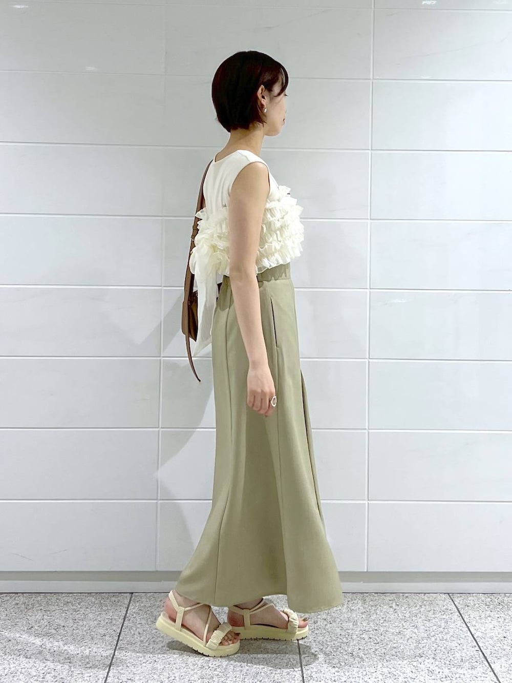 ホワイト系のサンダル、グリーン系のスカート、ブラウン系のショルダーバッグを着用したレディースの夏コーディネートの2枚目の写真