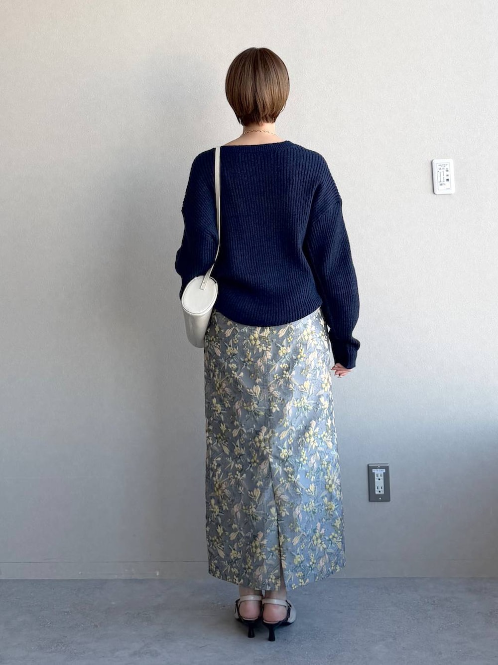 ホワイト系のショルダーバッグ、グレー系のスカート、ホワイト系のサンダルを着用したレディースの冬コーディネートの3枚目の写真