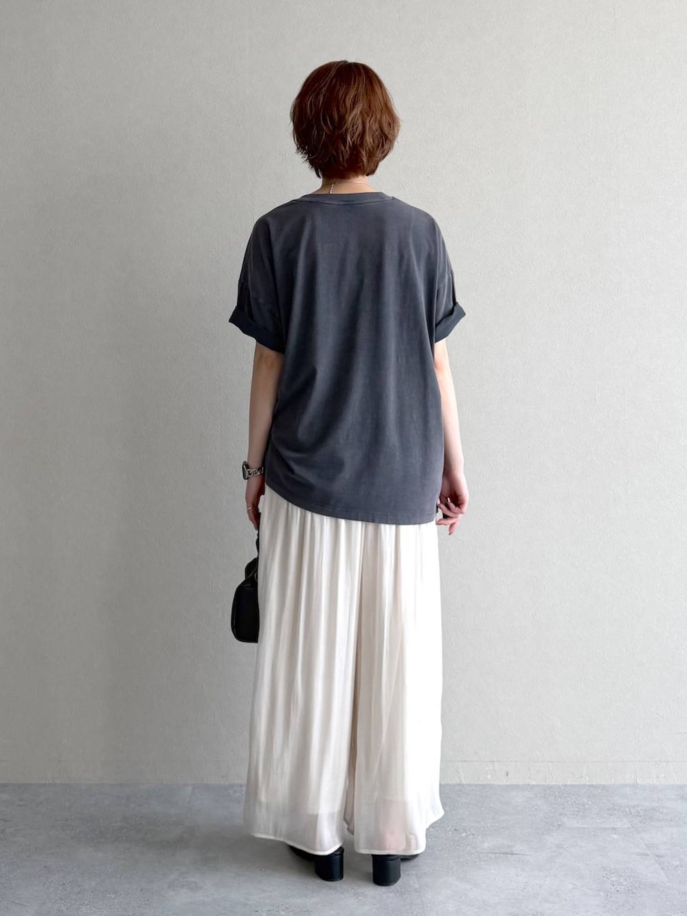 ブラック系のショルダーバッグ、グレー系のTシャツ/カットソー、ブラック系のサンダルを着用したレディースの夏コーディネートの3枚目の写真
